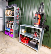 Modular industrial shelving units with various tools and storage containers on them, placed against a green wall in a workspace.